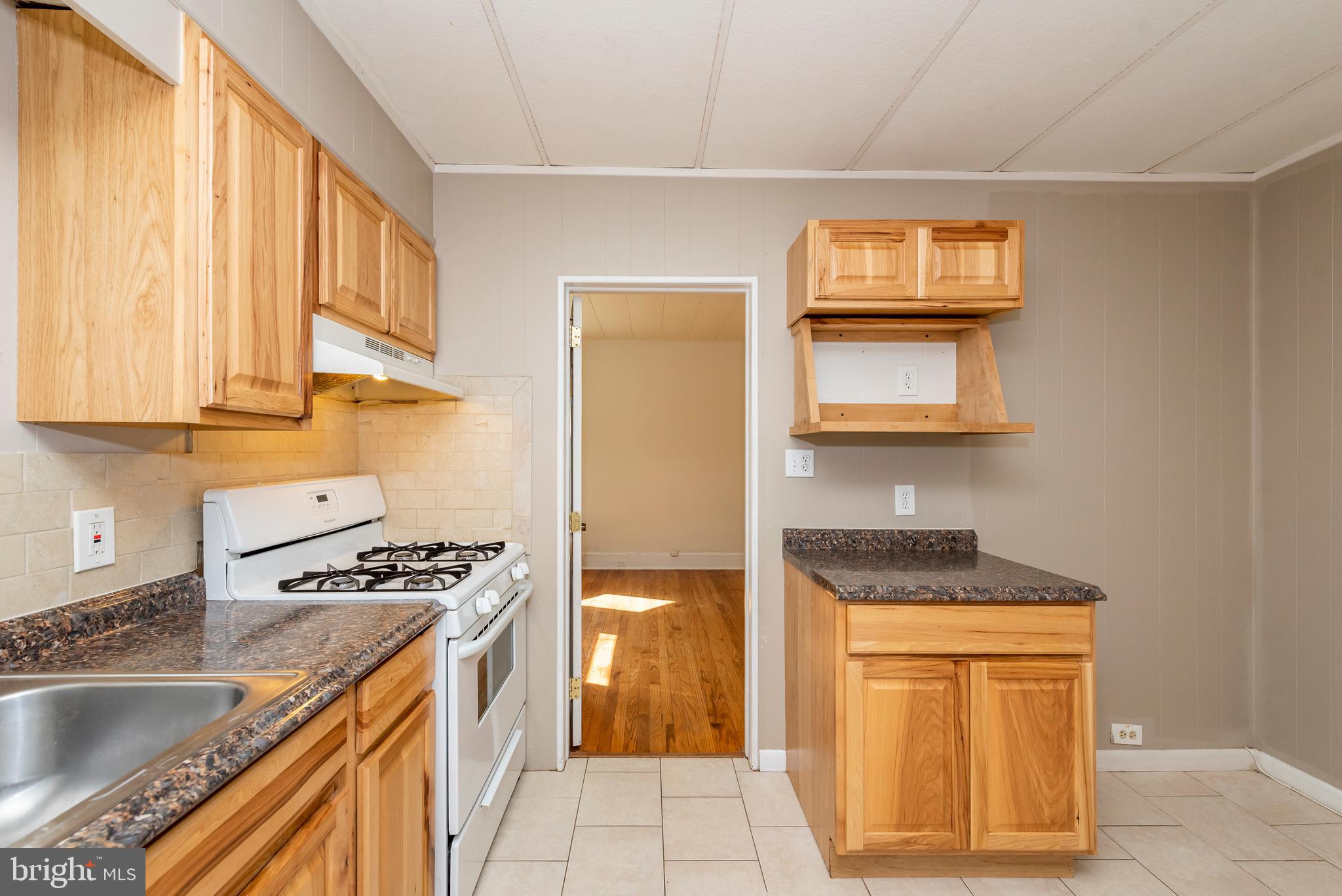 811 Dorchester Road Baltimore, MD 21229 - Photo 14 of 45 a kitchen with stainless steel appliances granite countertop a sink stove and cabinets