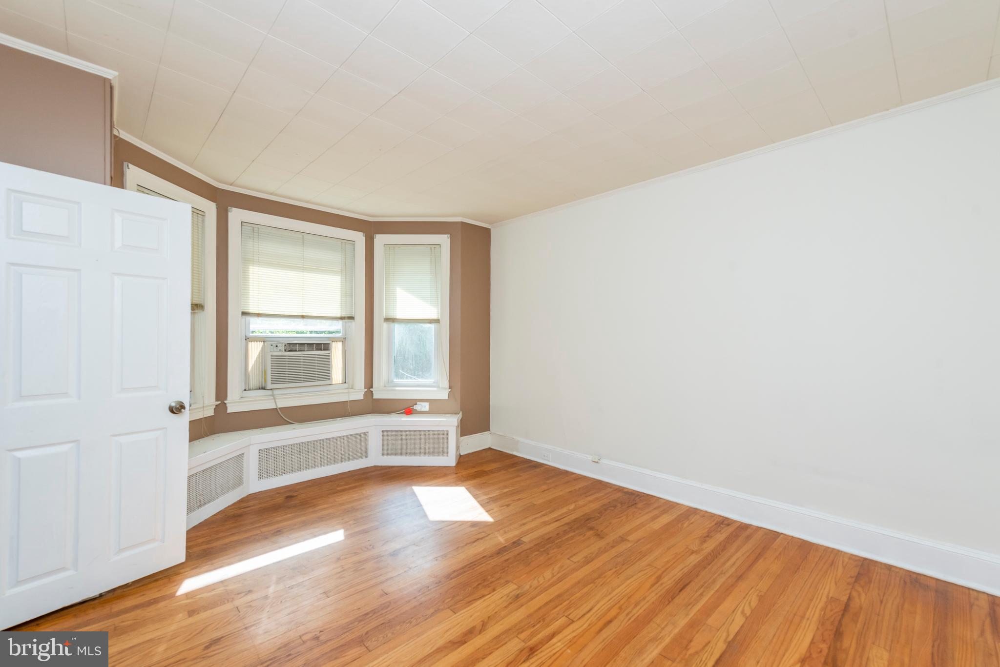 811 Dorchester Road Baltimore, MD 21229 - Photo 16 of 45 an empty room with wooden floor and windows