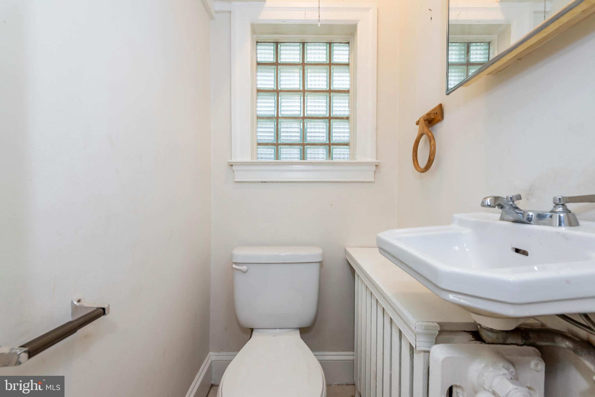 811 Dorchester Road Baltimore, MD 21229 - Photo 18 of 45 a bathroom with a sink a toilet and a window