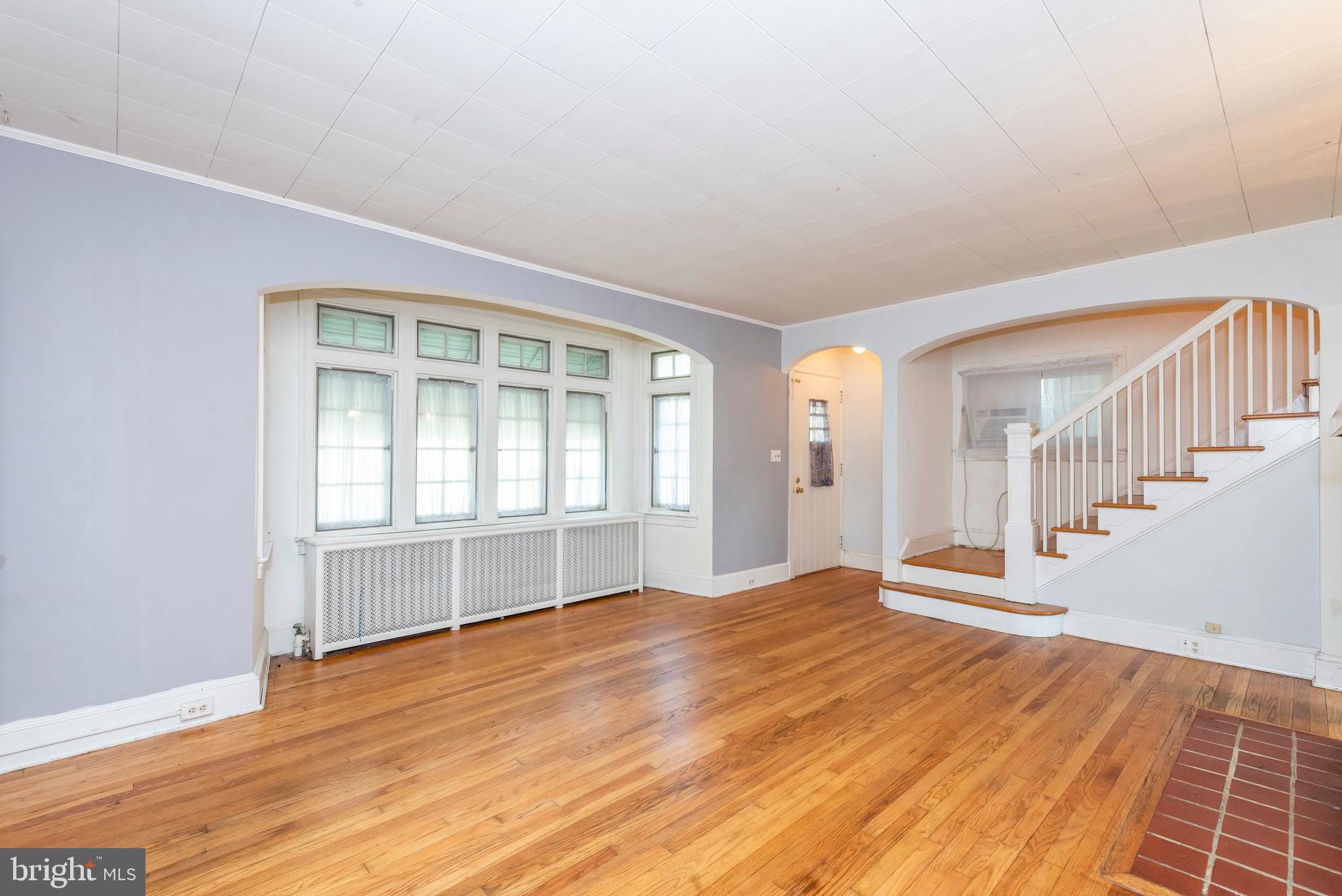 811 Dorchester Road Baltimore, MD 21229 - Photo 3 of 45 a view of an empty room with wooden floor and a window