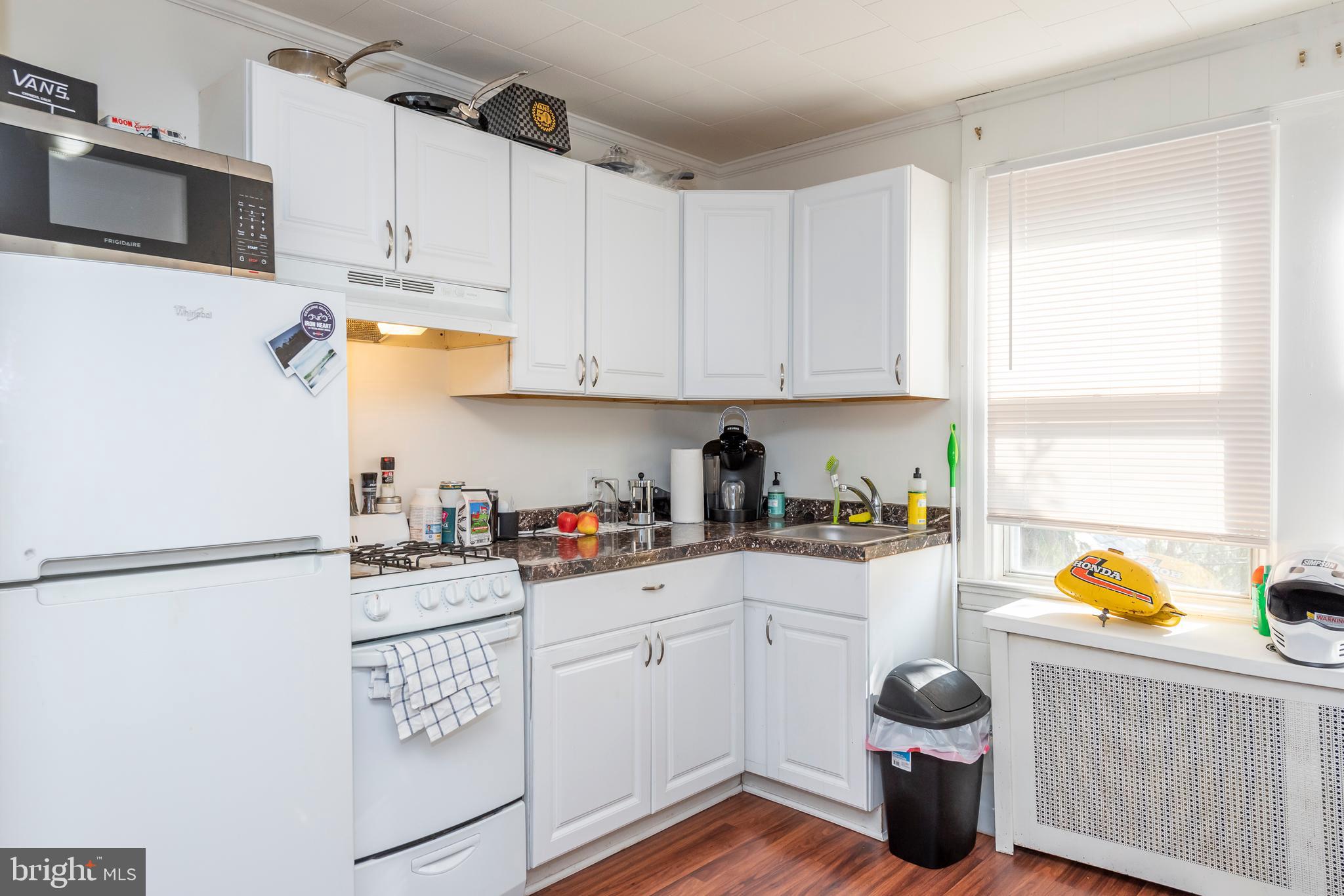 811 Dorchester Road Baltimore, MD 21229 - Photo 23 of 45 a kitchen with stainless steel appliances a sink a stove a refrigerator cabinets and a window