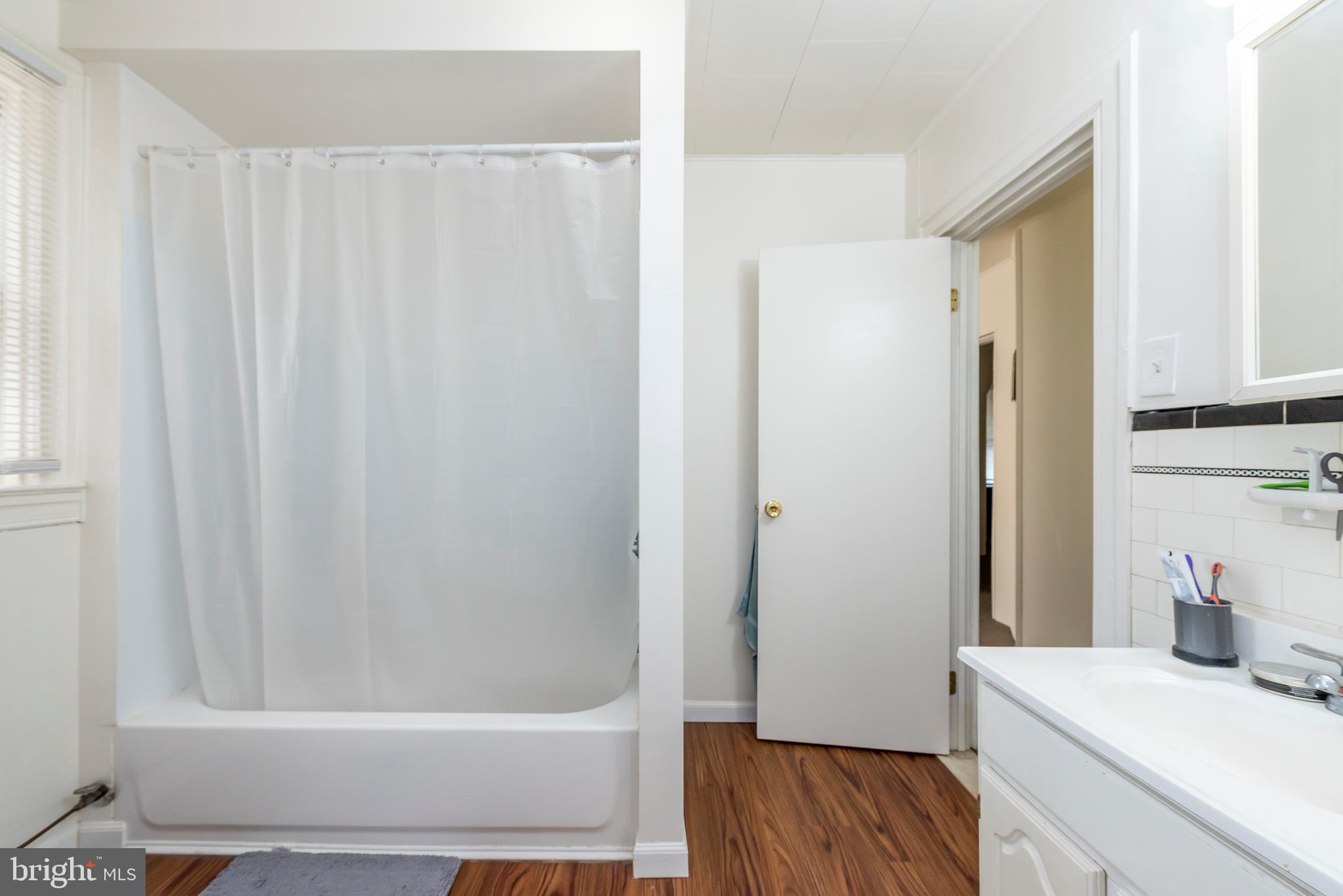 811 Dorchester Road Baltimore, MD 21229 - Photo 34 of 45 a bathroom with a bathtub a sink and a shower