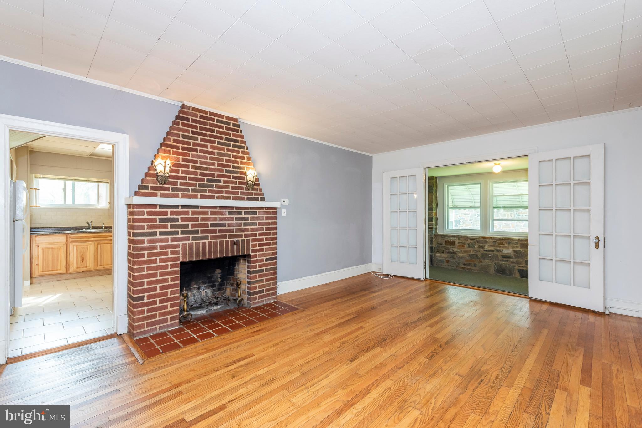 811 Dorchester Road Baltimore, MD 21229 - Photo 5 of 45 an empty room with wooden floor fireplace and windows