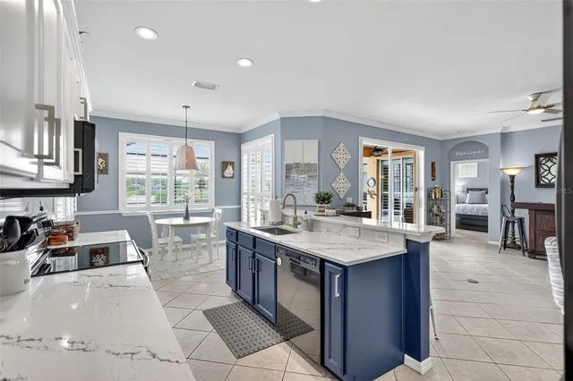 a kitchen with stainless steel appliances kitchen island granite countertop a refrigerator a stove a microwave oven a dining table and chairs with wooden floor