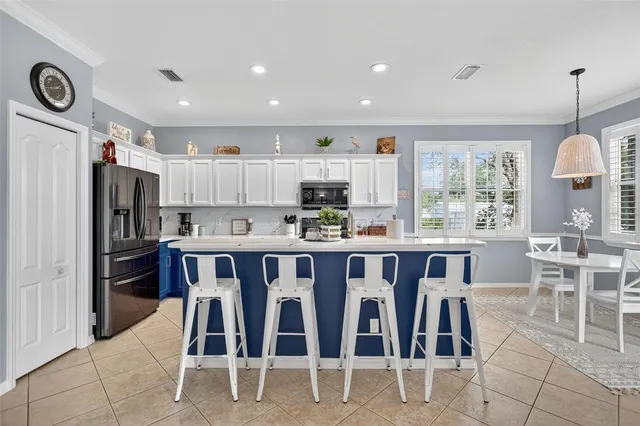 a kitchen with stainless steel appliances granite countertop a refrigerator a stove top oven a sink dishwasher and white cabinets with wooden floor
