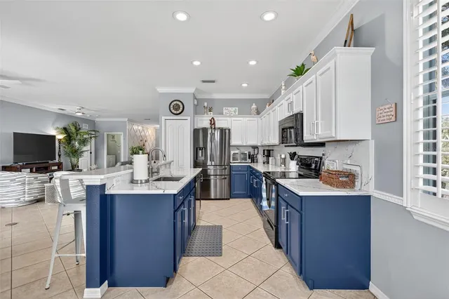 a large kitchen with kitchen island a large counter top stainless steel appliances and cabinets