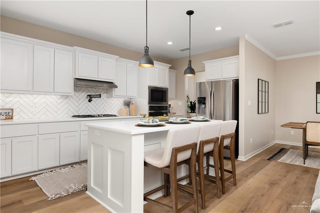 6343 Cascada Bnd Road McAllen, TX 78504 - Photo 13 of 35 a kitchen with stainless steel appliances granite countertop a stove a refrigerator a oven a sink a table and chairs