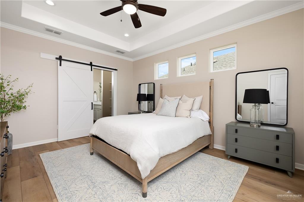 6343 Cascada Bnd Road McAllen, TX 78504 - Photo 19 of 35 a bedroom with a large bed and a chandelier