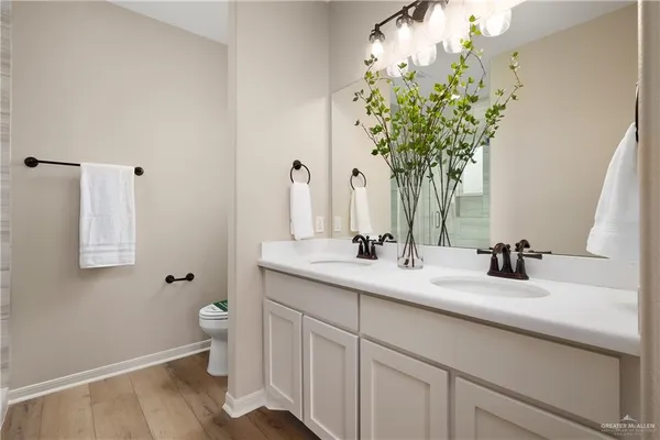 a bathroom with a sink a toilet and a mirror