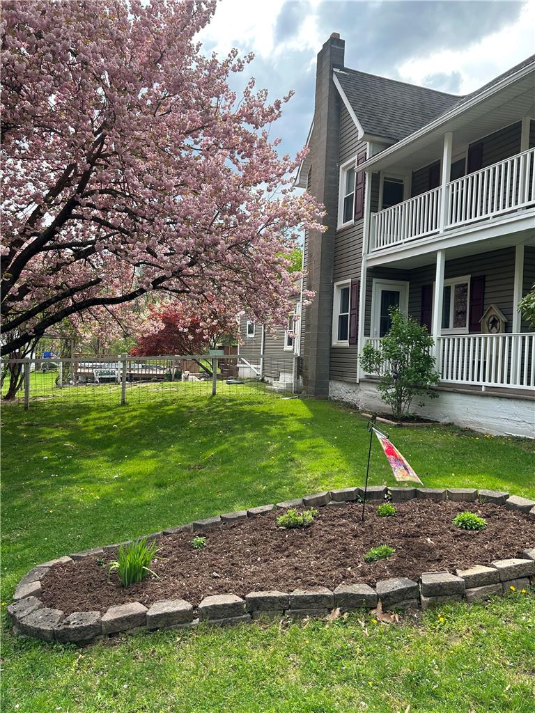 1114 Fox Gap Road Bangor, PA 18013 - Photo 50 of 63 A tiered back porch overlooks a grassy yard framed by blossoming trees.