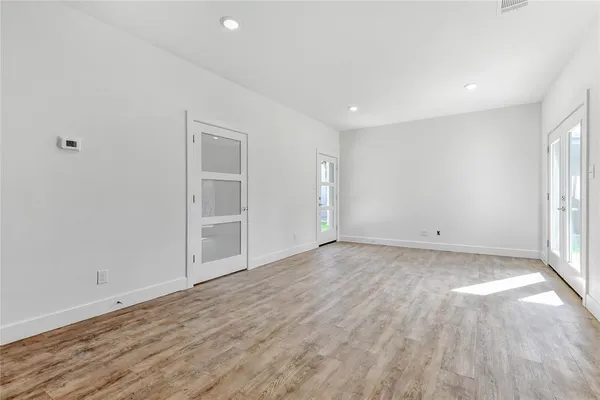 a view of empty room with wooden floor