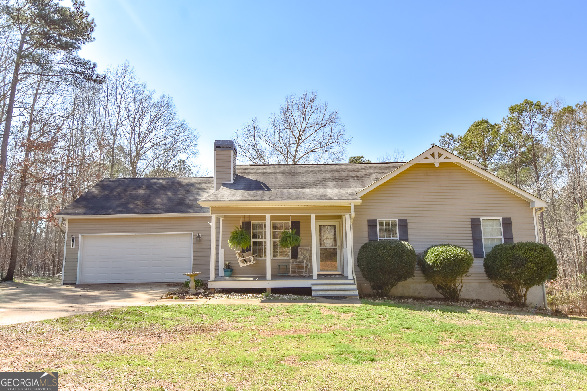 a view of a house with a yard and large tree
