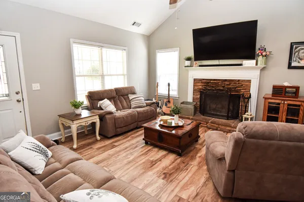 a living room with furniture a flat screen tv and a fireplace