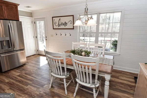 a dining room with furniture a chandelier and wooden floor
