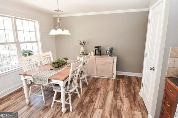 a view of a dining room with furniture a chandelier and wooden floor