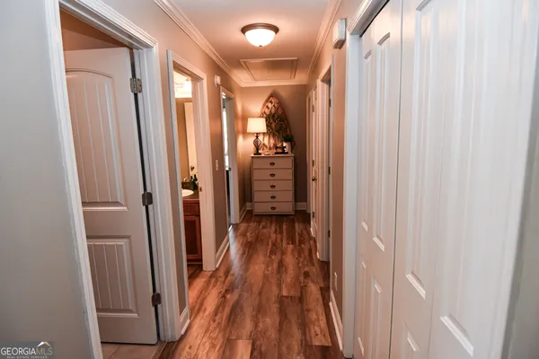 a view of a hallway with wooden floor and closet