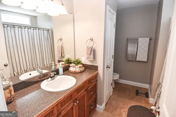 a bathroom with a sink double vanity granite and a mirror