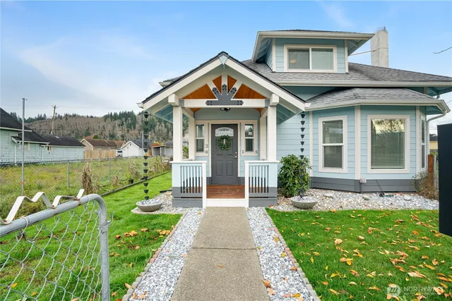a front view of a house with a yard and potted plants