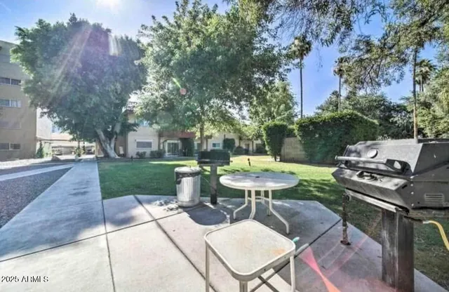 a view of a patio with table and chairs and a barbeque