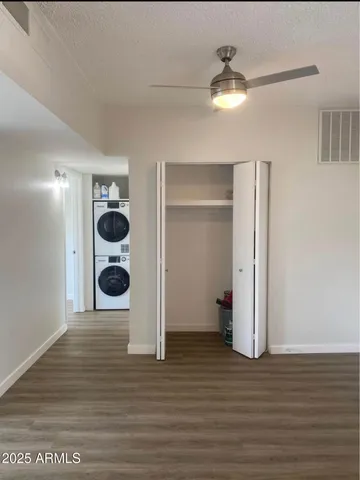 a view of a room with wooden floor and a ceiling fan