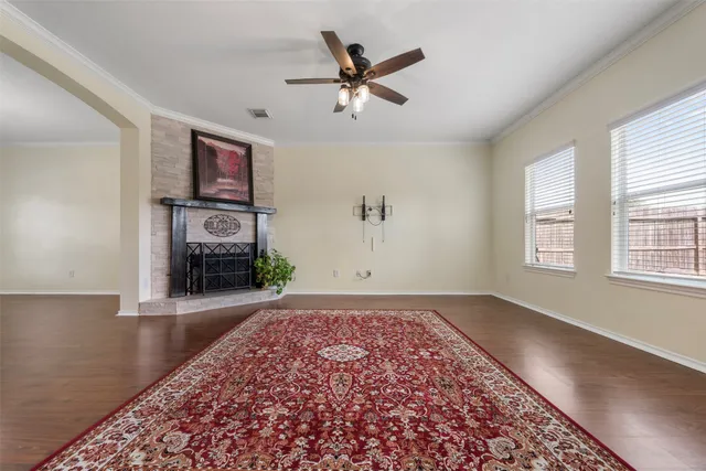 an empty room with ceiling fan and windows