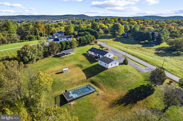 an aerial view of a house with a garden and lake view