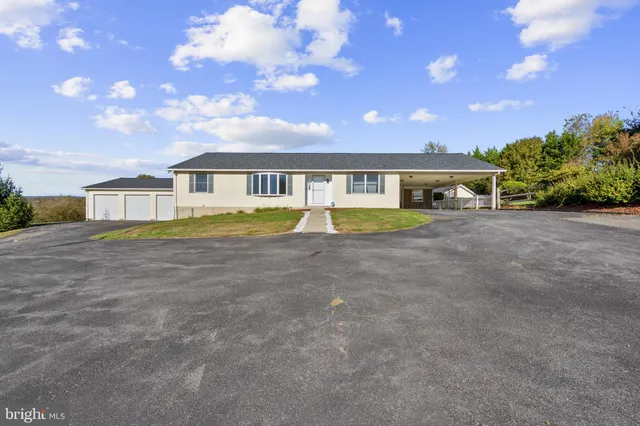 a front view of a house with a garden and lake view