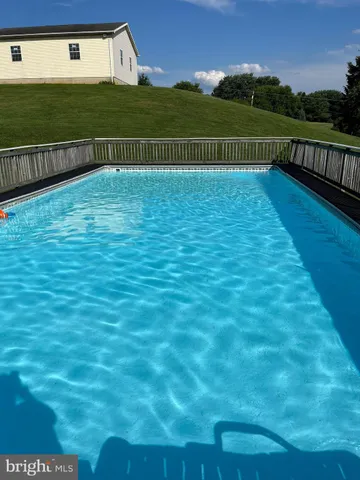 a view of a house with swimming pool and a yard