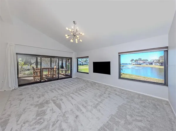 an empty room with windows and fireplace