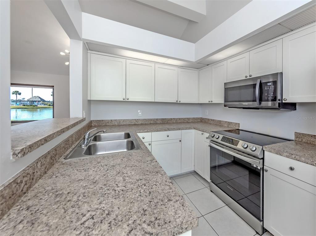 764 Sarabay Road, Unit 8 Osprey, FL 34229 - Photo 20 of 64 a kitchen with granite countertop a sink cabinets and stainless steel appliances