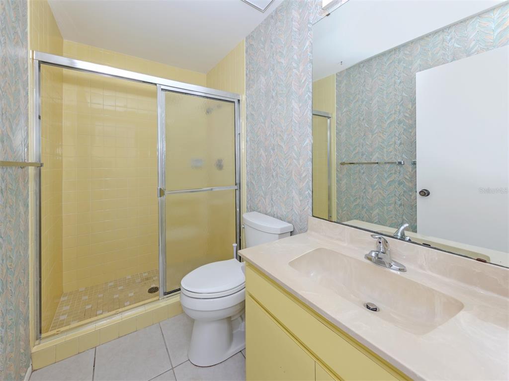 764 Sarabay Road, Unit 8 Osprey, FL 34229 - Photo 35 of 64 a bathroom with a shower sink vanity mirror and toilet