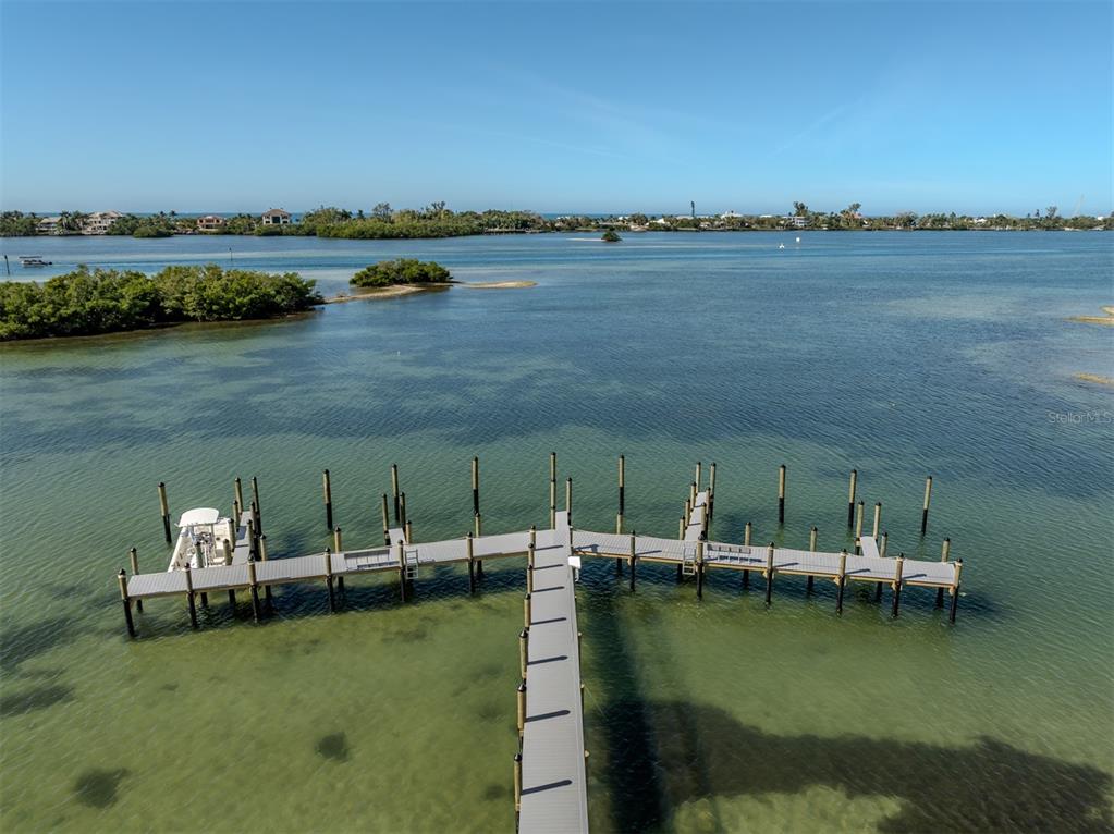 764 Sarabay Road, Unit 8 Osprey, FL 34229 - Photo 44 of 64 a view of a lake with boats and trees in the background
