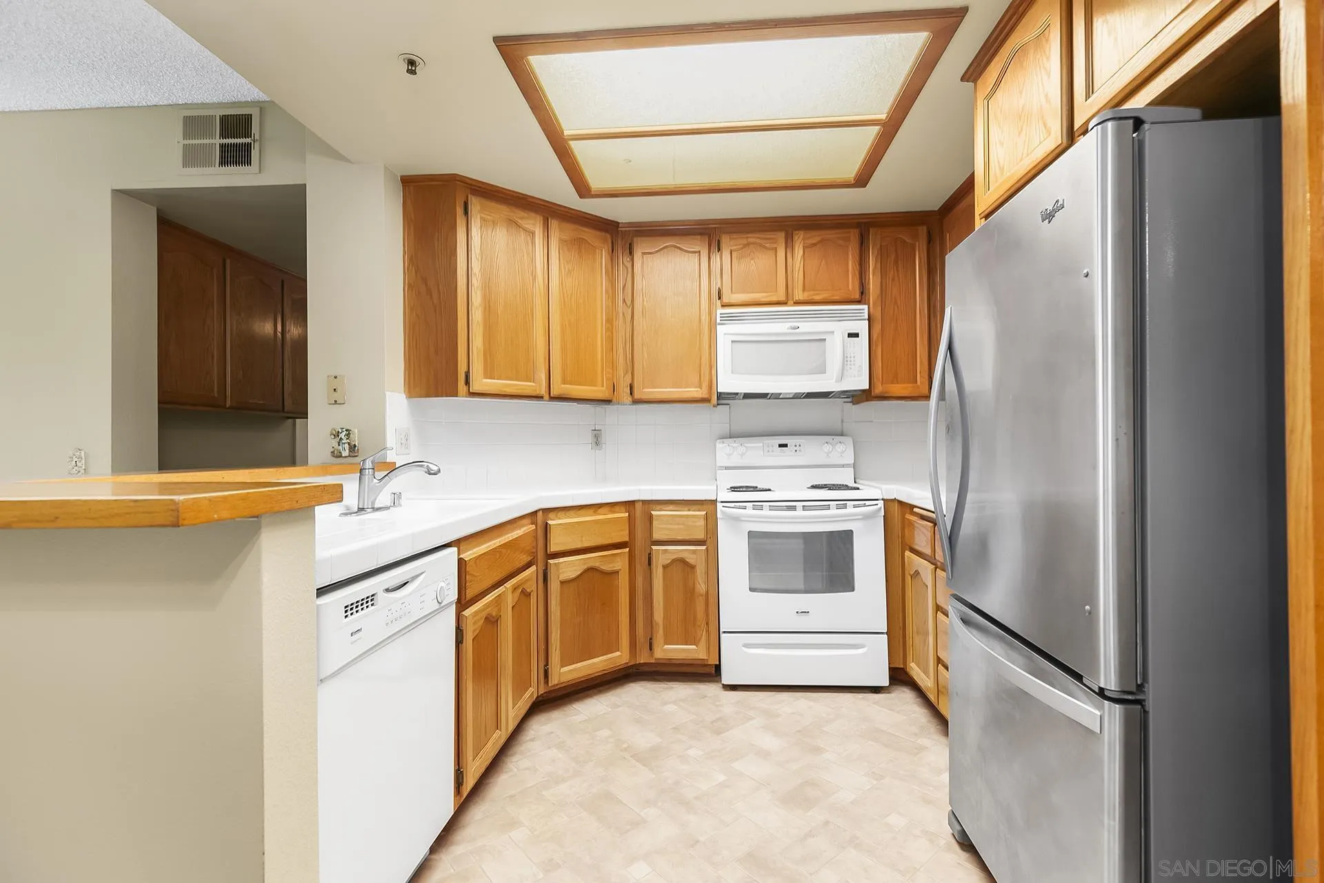 5875 Friars Road, Unit 4307 San Diego, CA 92110 - Photo 7 of 26 a kitchen with stainless steel appliances granite countertop a refrigerator a sink and a stove