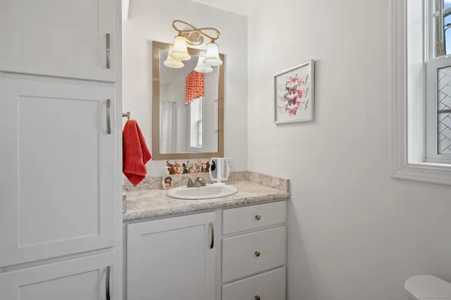 a bathroom with a granite countertop sink and a mirror