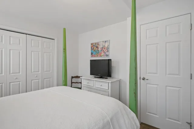 a bedroom with a bed and a flat screen tv