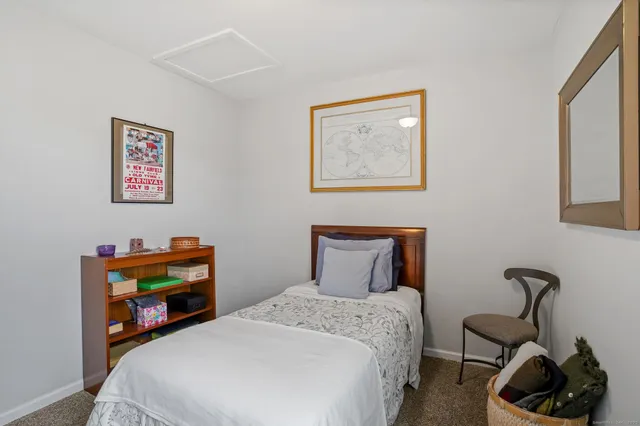 a bedroom with bed and a painting on the wall
