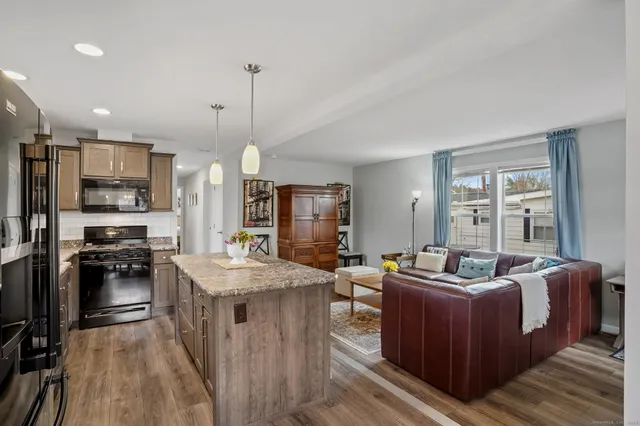 a living room with stainless steel appliances granite countertop furniture and a kitchen view