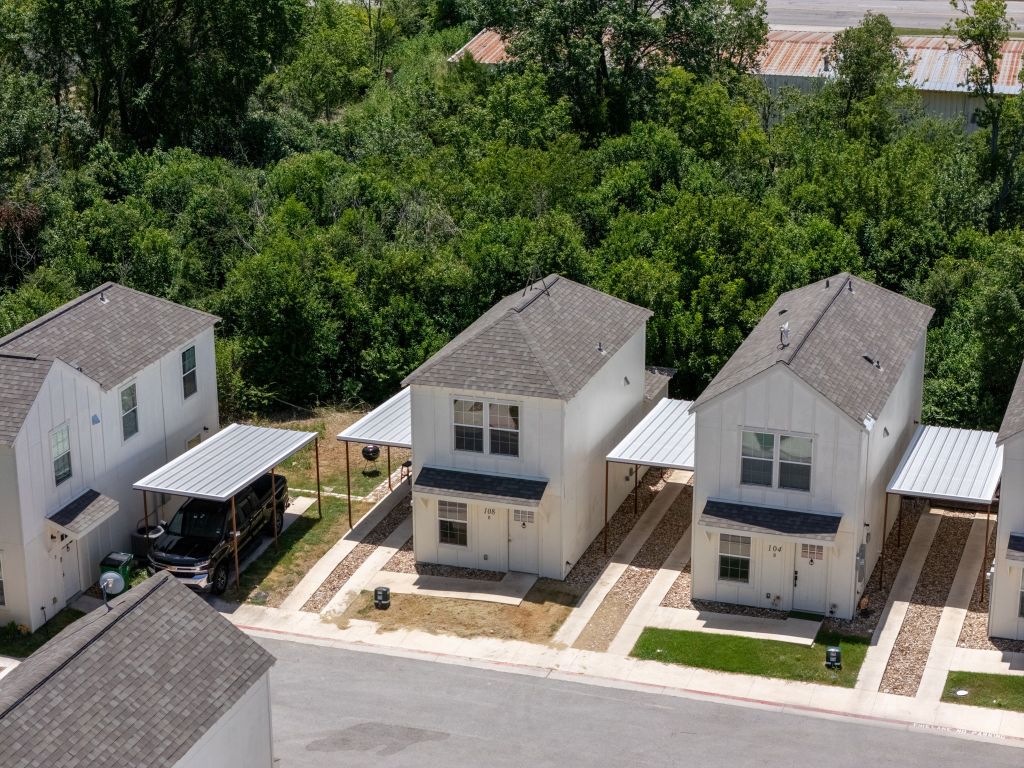 230 Debus Drive, Unit 101 Taylor, TX 76574 - Photo 17 of 17 an aerial view of a house with wooden fence and large trees