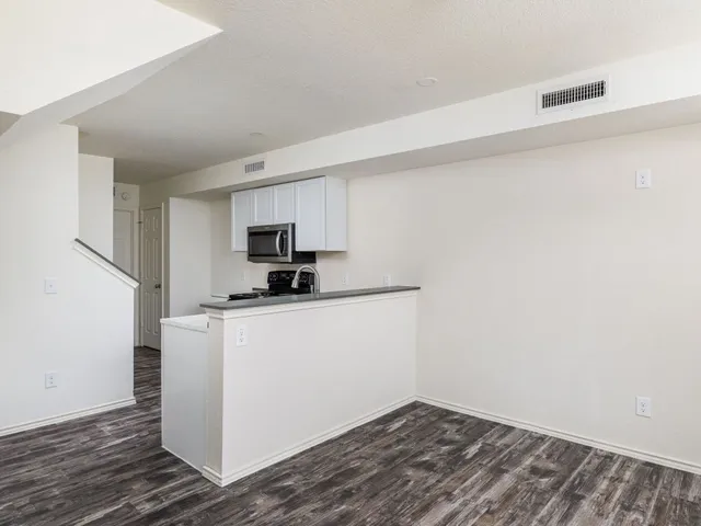 a kitchen with cabinets appliances and wooden floor