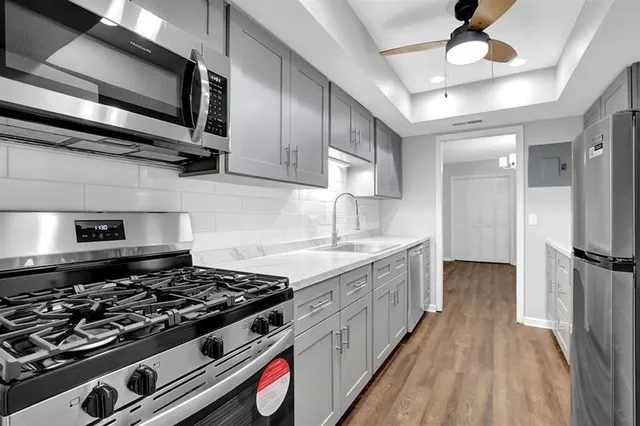 a kitchen with stainless steel appliances a stove a sink and a refrigerator