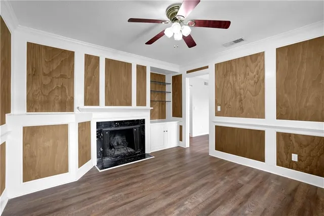 a view of an empty room with wooden floor fireplace and a window