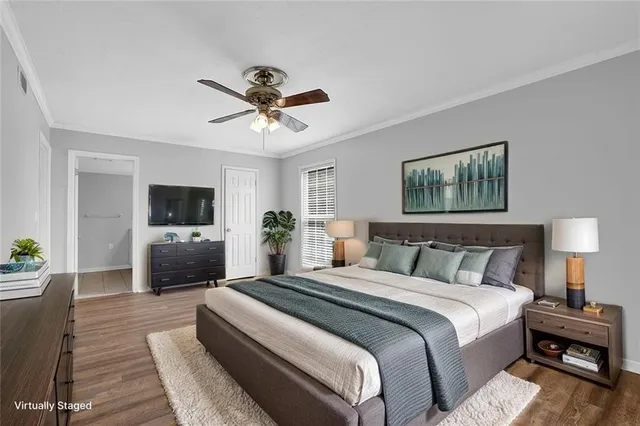 a bedroom with a bed a couch and a flat screen tv