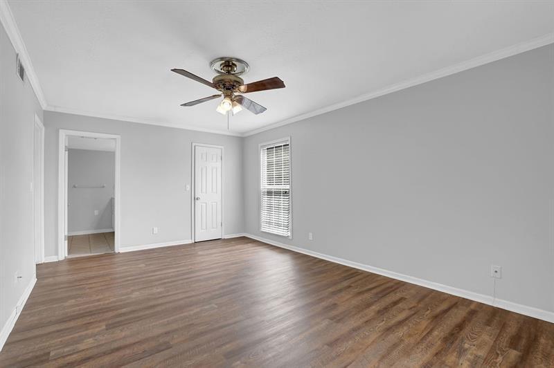 6851 Roswell Road, Unit C7 Atlanta, GA 30328 - Photo 18 of 28 a view of an empty room with wooden floor and a ceiling fan