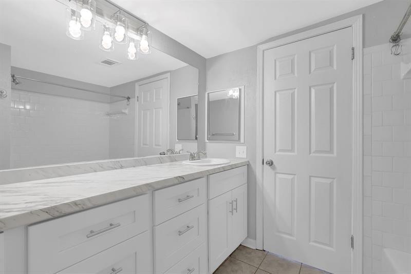 6851 Roswell Road, Unit C7 Atlanta, GA 30328 - Photo 22 of 28 a bathroom with a double vanity sink and a mirror