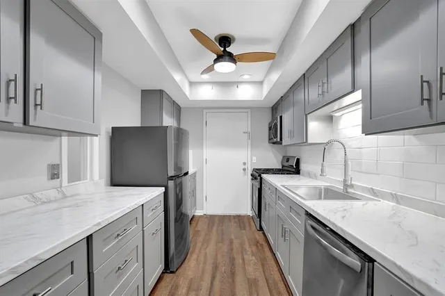 a kitchen with granite countertop a sink stainless steel appliances and counter space