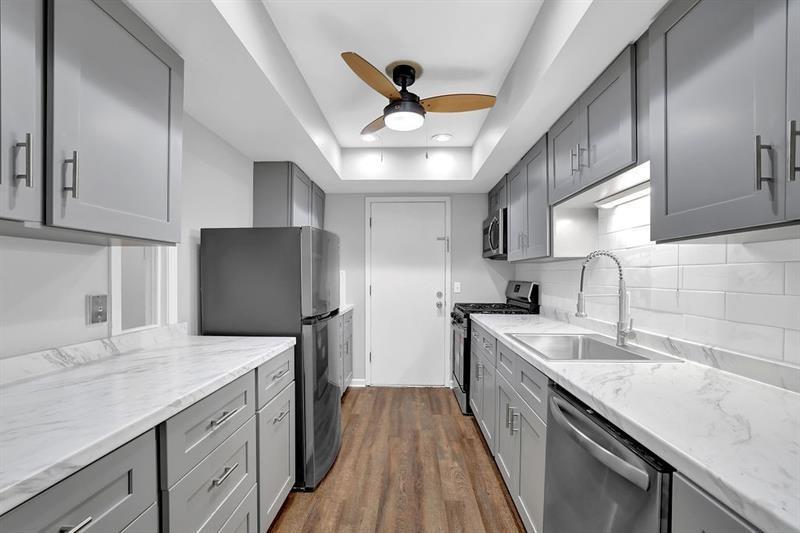6851 Roswell Road, Unit C7 Atlanta, GA 30328 - Photo 4 of 28 a kitchen with granite countertop a sink stainless steel appliances and counter space