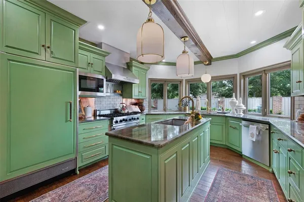 a kitchen with stainless steel appliances granite countertop a sink and a refrigerator