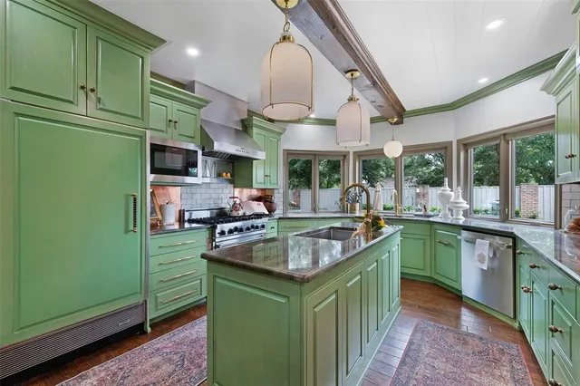 a kitchen with stainless steel appliances granite countertop a sink and a refrigerator