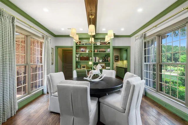a dining room with furniture large windows and wooden floor
