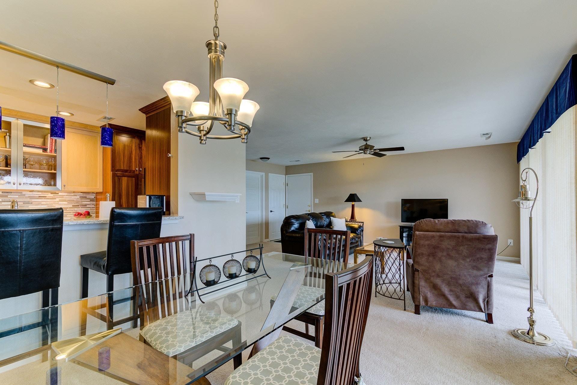 835 Gangplank Road, Unit 103 Moneta, VA 24121 - Photo 11 of 34 a living room with furniture a chandelier and a dining table